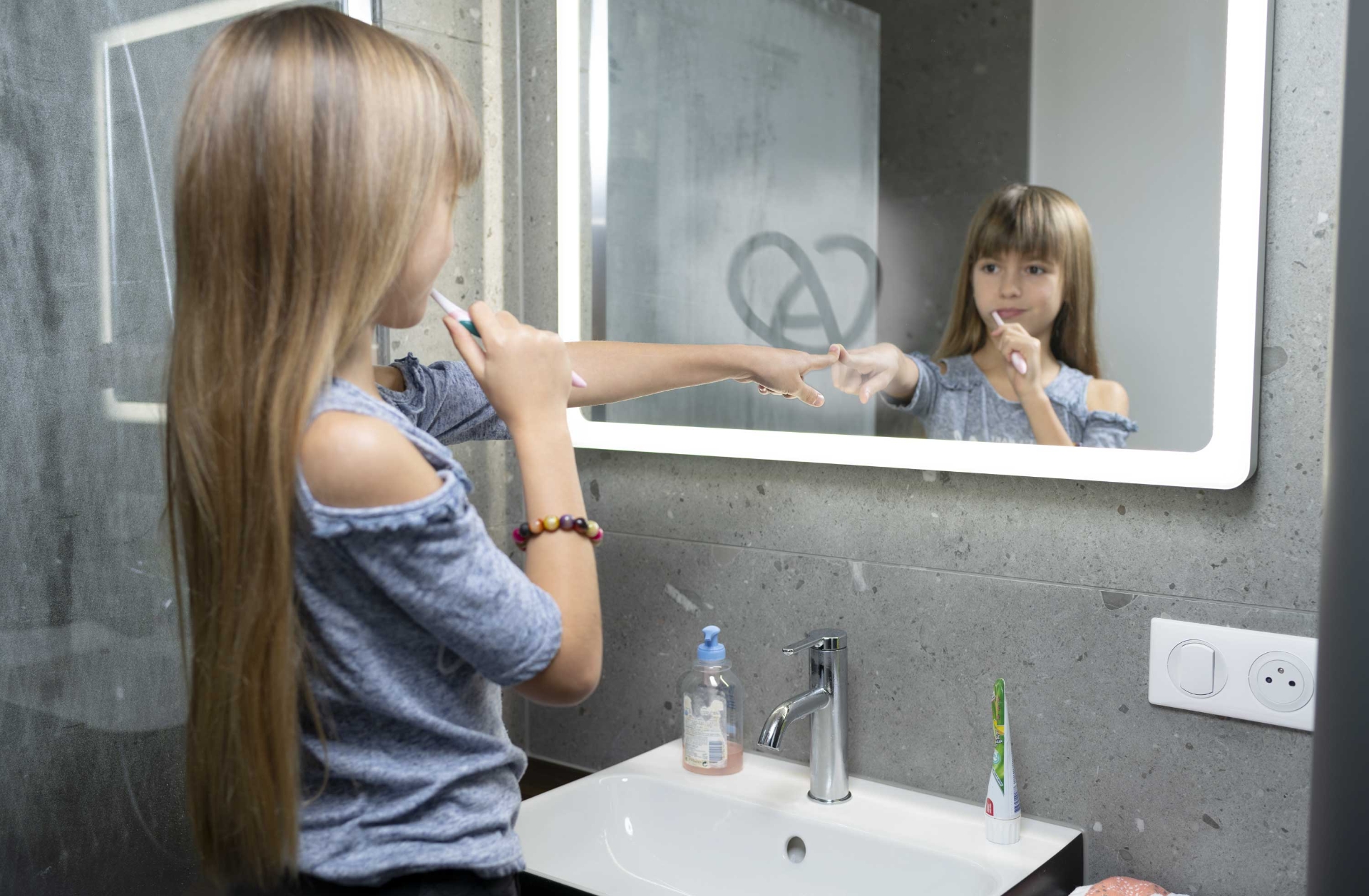 enfant devant un miroir de salle de bain