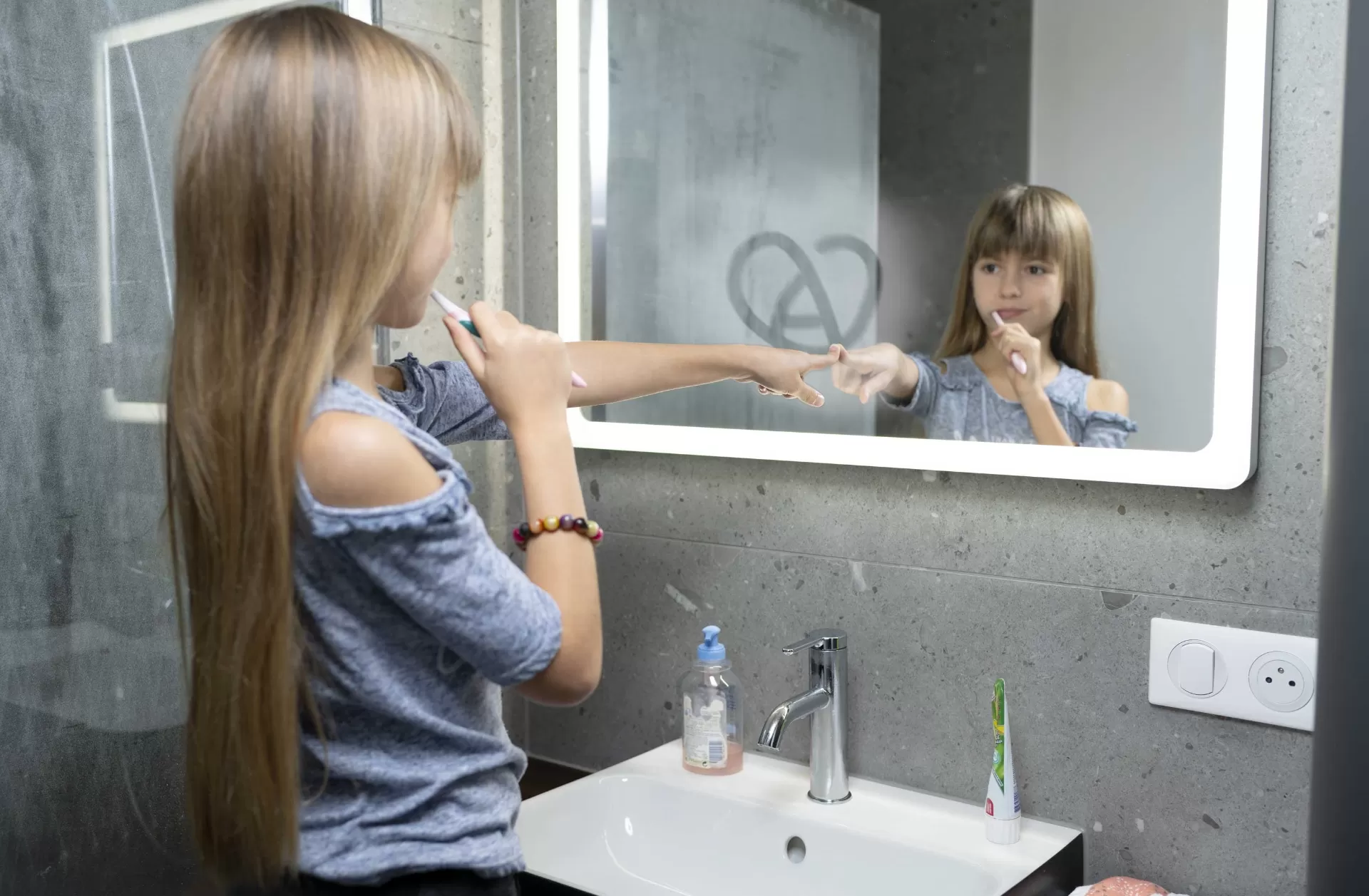 enfant devant un miroir de salle de bain